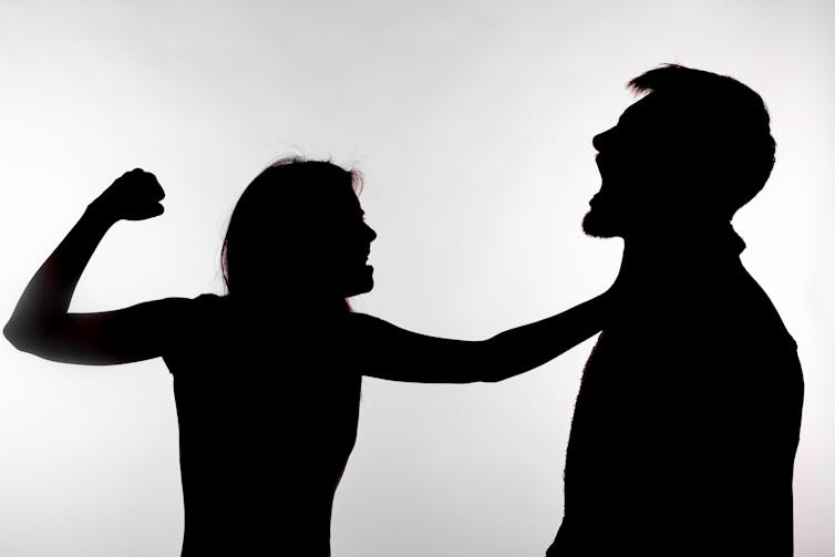 Silhouette of a woman slapping a man