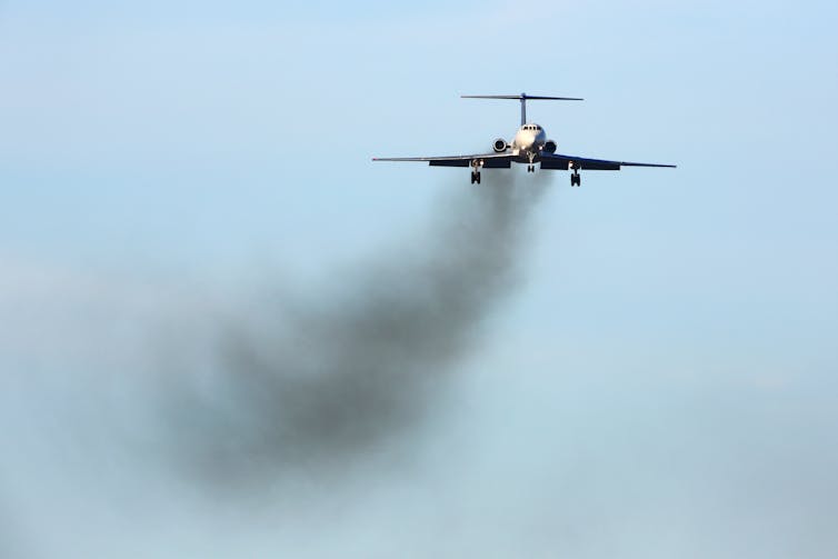 An aeroplane with black exhaust fumes.