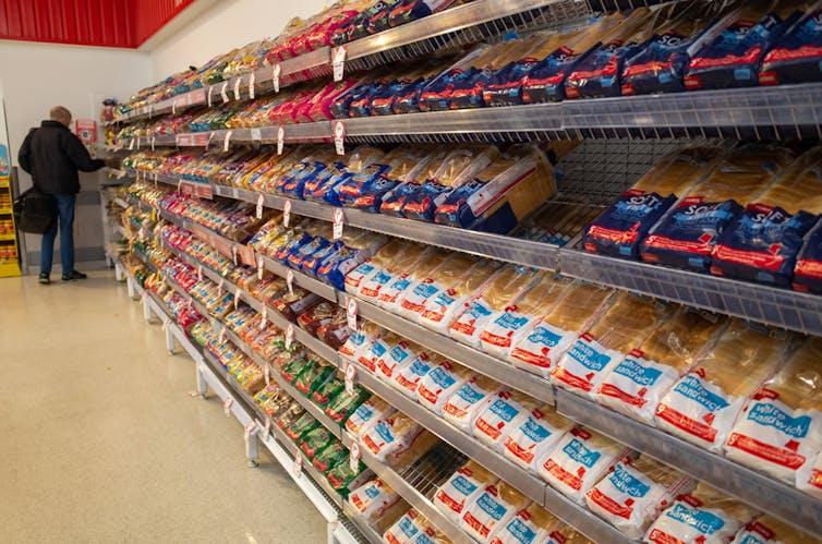 Rows of packaged bread on supermarket shelf