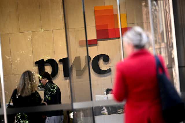 blurred figures seen out front of PwC Australia offices in Melbourne