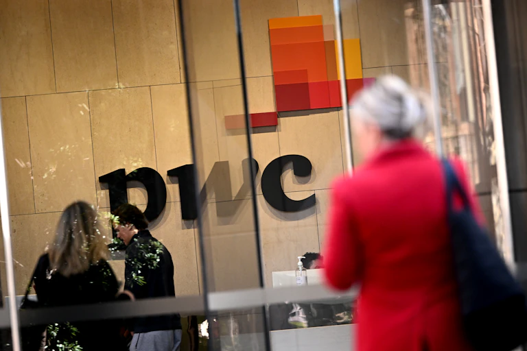 blurred figures seen out front of PwC Australia offices in Melbourne