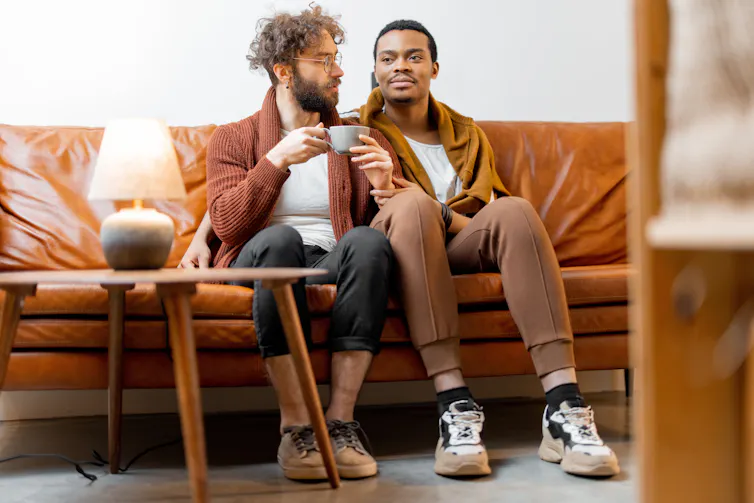 Two men sitting together on a couch.