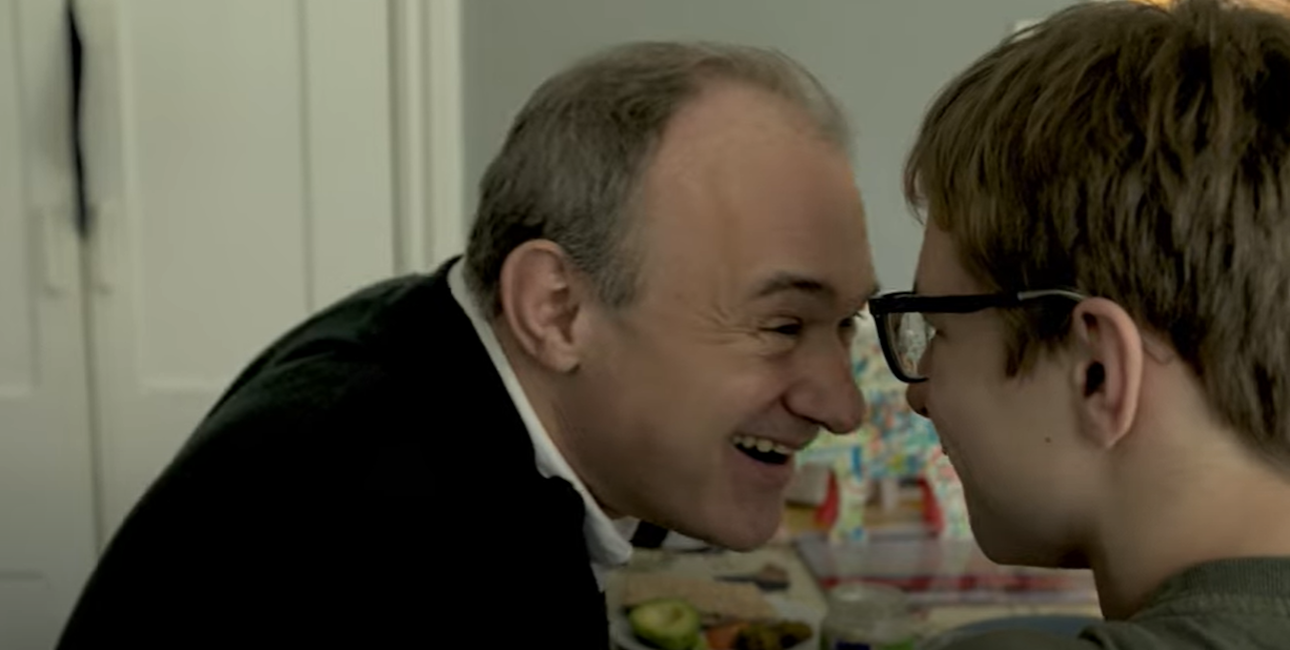 Clip of Ed Davey smiling and touching foreheads with his teenage son John, at home