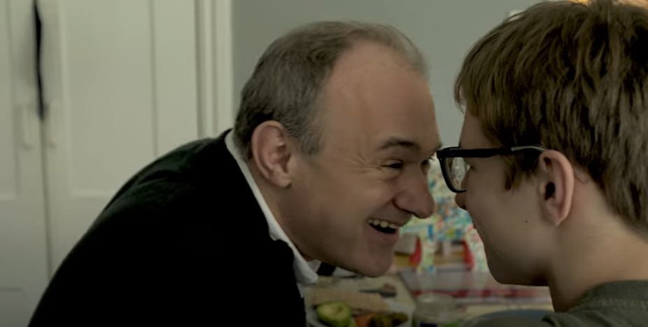 Clip of Ed Davey smiling and touching foreheads with his teenage son John, at home