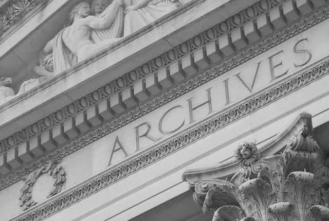 A detail from a large building that has the word 'ARCHIVES' on it.