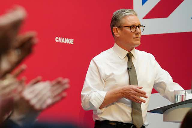 Keir Starmer giving a speech in front of the word 'change' printed on a wall