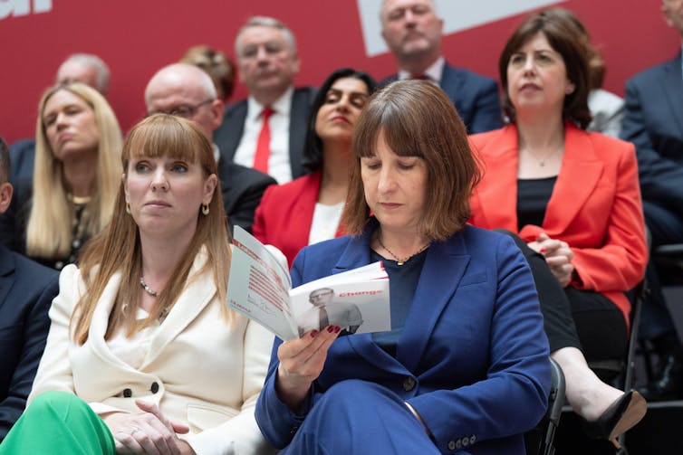 Rachel Reeves lendo o manifesto trabalhista, sentada ao lado de Angela Rayner.