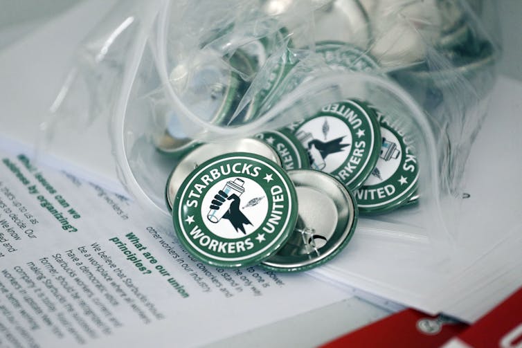 A stack of green and white Starbucks Workers United buttons