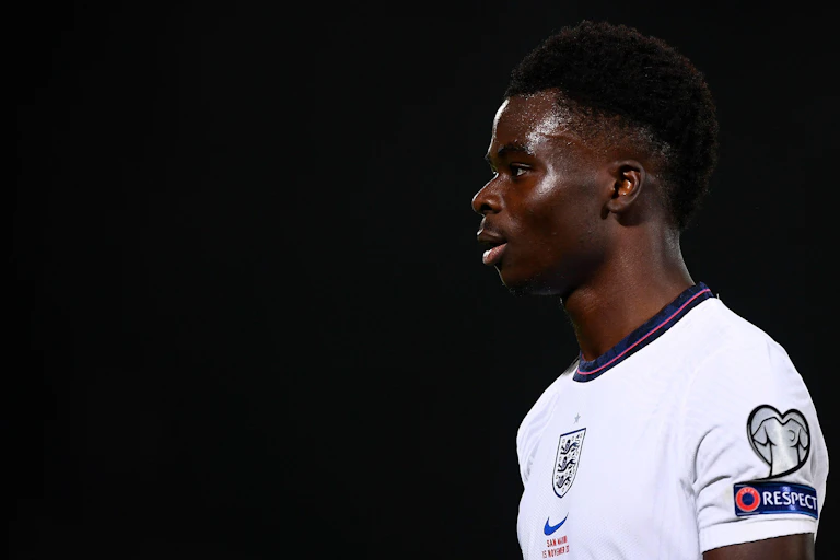 Bukayo Saka, a young black English player in an England shirt.