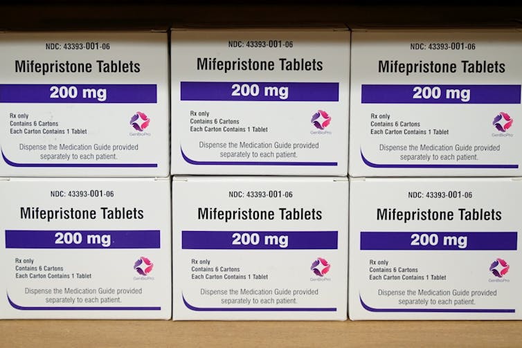 Boxes of drugs labeled mifepristone sit on a shelf