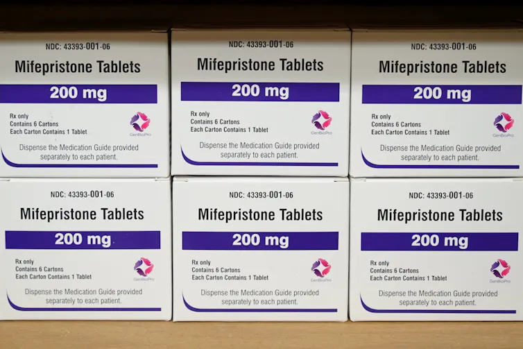 Boxes of drugs labeled mifepristone sit on a shelf