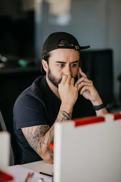 Anxious man bites nails holding phone to ear