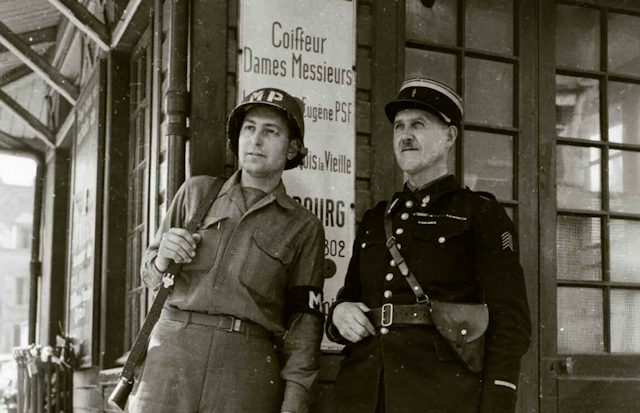 Un soldat américain à côté d'un gendarme à Cherbourg en juillet 1944.