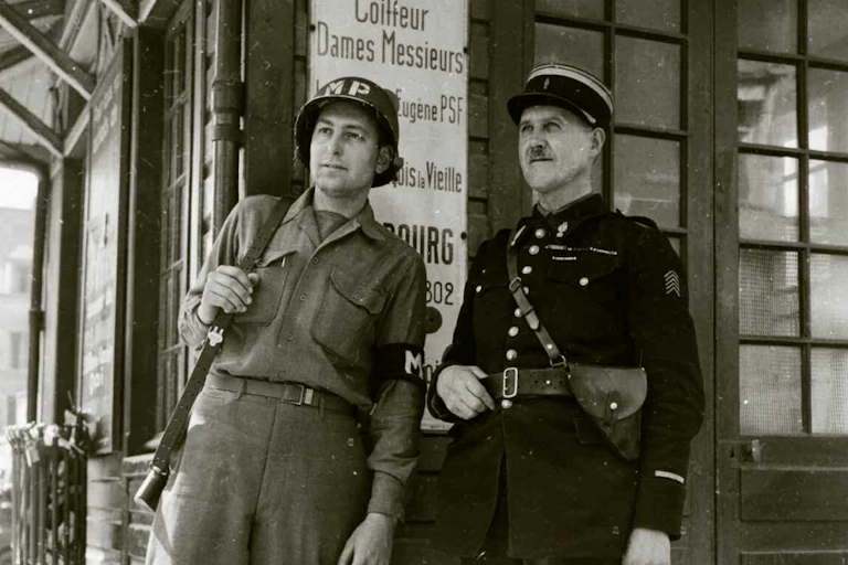 Un soldat américain à côté d'un gendarme à Cherbourg en juillet 1944.