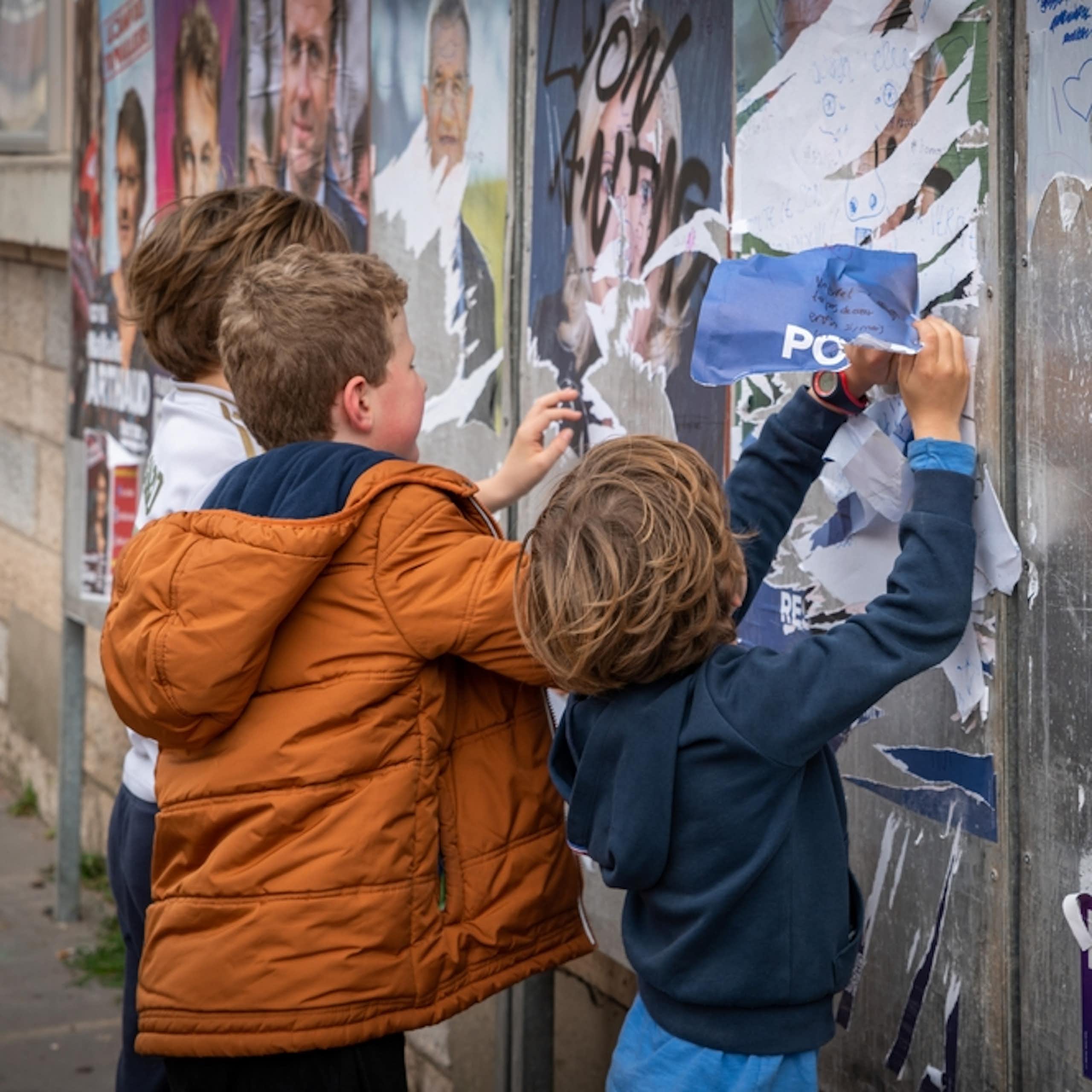 Des enfants déchirant des affiches de candidats à l'élection présidentielle en France