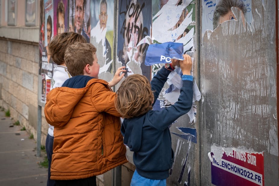 Des enfants déchirant des affiches de candidats à l'élection présidentielle en France