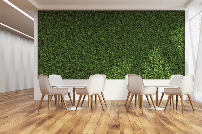 Un espace de détente avec un mur végétal, un parquet en bois et des meubles clairs