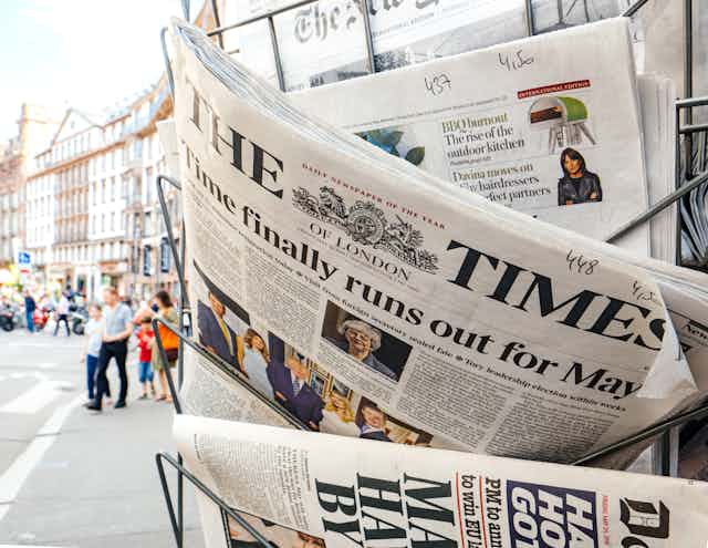 Close up of a news stand with British publications like the Times