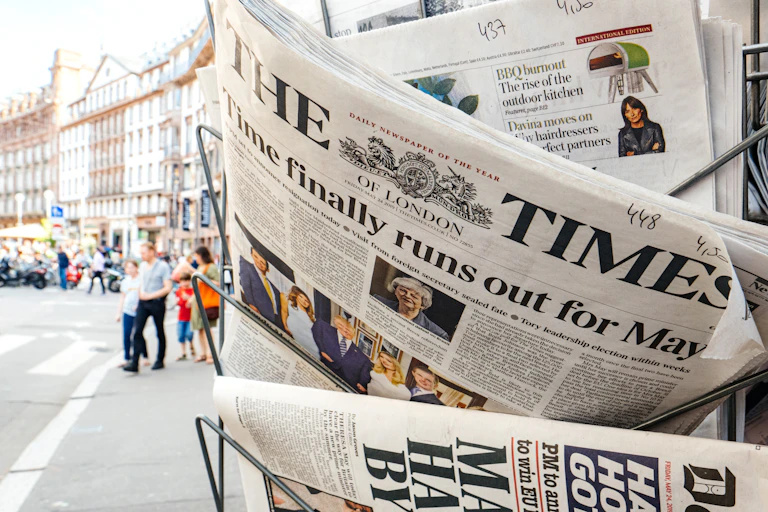 Close up of a news stand with British publications like the Times
