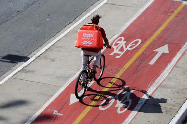 Aerial view of a person riding a bike in a bicycle lane with a food delivery backpack on