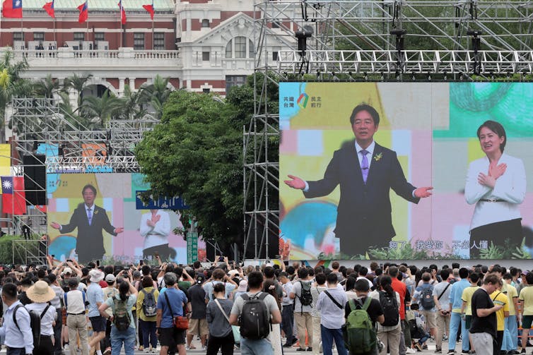 Man and woman appear on giant screens.