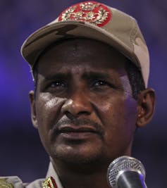 A man in a baseball cap frowns.