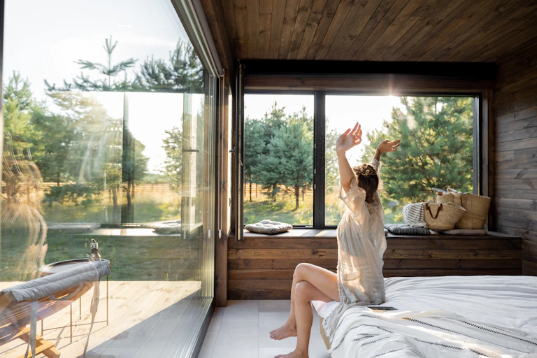 woman stretches after waking in retreat setting