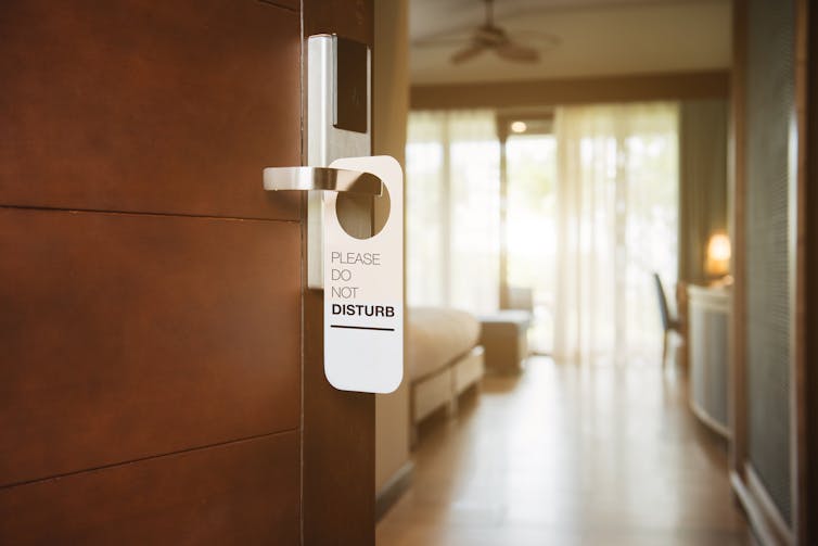 A do not disturb tag hangs on hotel door handle