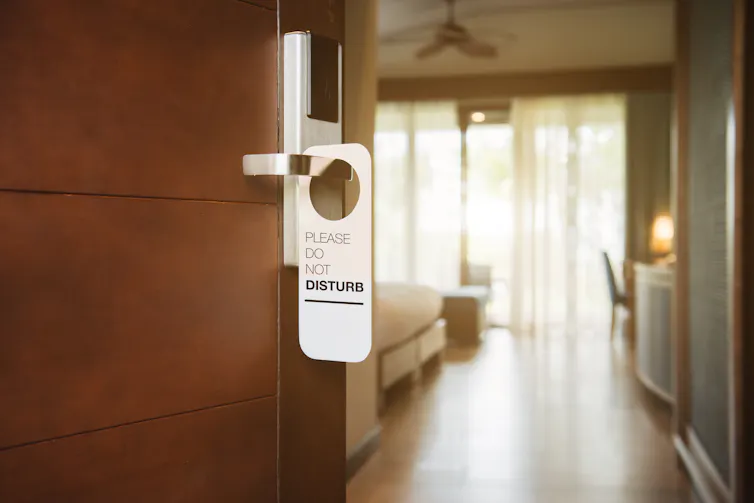 Uma etiqueta de não perturbe pendurada na maçaneta da porta do hotel