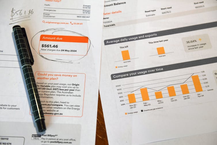a pen lies on two power bills