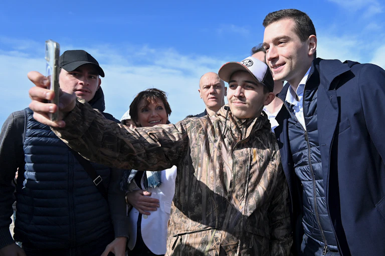 Le président du parti d'extrême droite Rassemblement national Jordan Bardella prend une photo avec un supporter au Grau du Roi, dans le sud de la France, le 2 mars 2024.