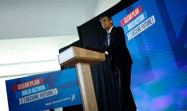 rishi sunak standing at a podium launching his manifesto