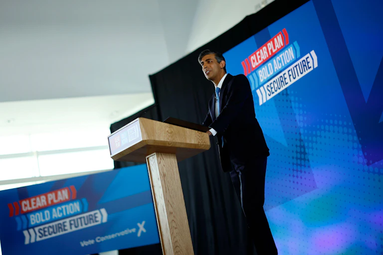 rishi sunak standing at a podium launching his manifesto