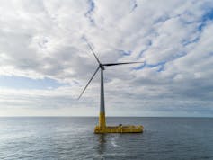 Eolienne sur un fond de mer et ciel nuageux