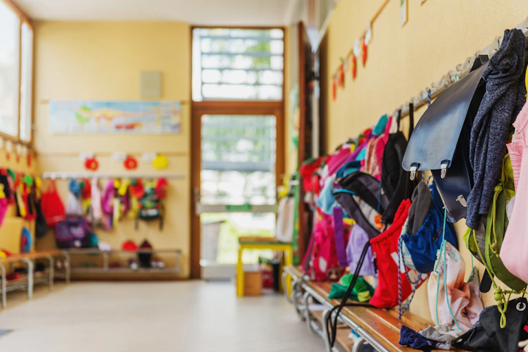 A hallway seen with children's bags and coats.