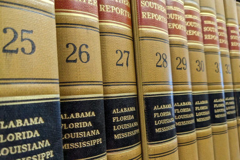 A row of law books are displayed on a table.