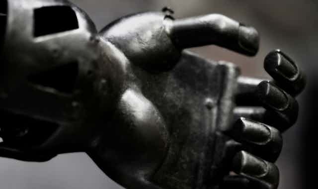 Imagem em close-up de uma mão de ferro, com os dedos frouxamente enrolados