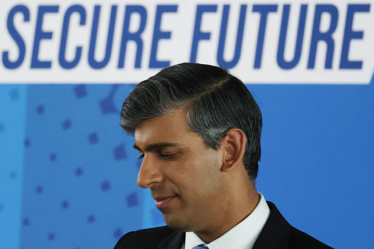 Rishi Sunak in front of a sign reading 'secure future'.