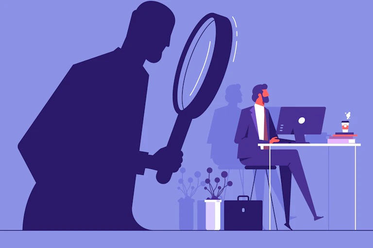 An illustration of someone working at a desk, in a business suit, while a shadowy figure watches, unseen, holding a giant magnifying glass