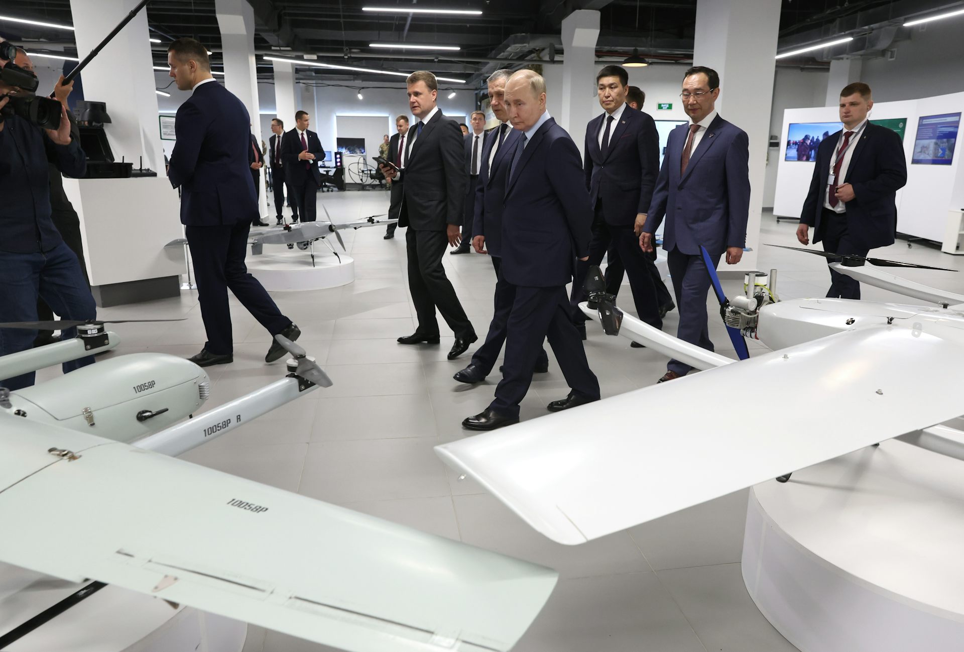 Russian president Vladimir Putin with his entourage walks around a factory making drones.