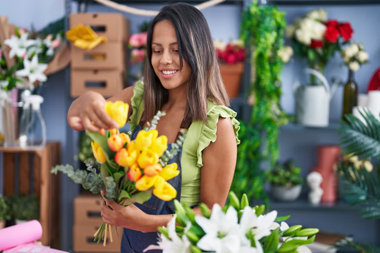 Florist arranging a bunch of yellow tulips