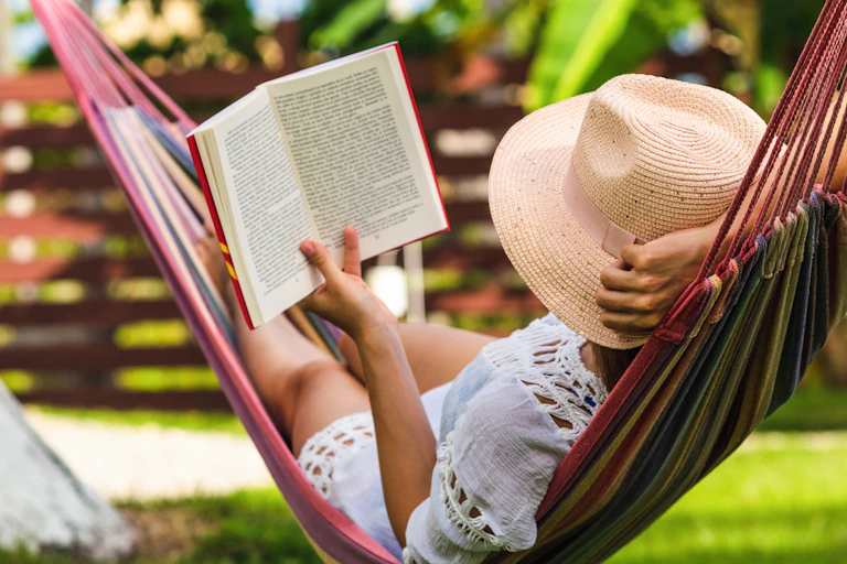 A woman in a hammock with a book.