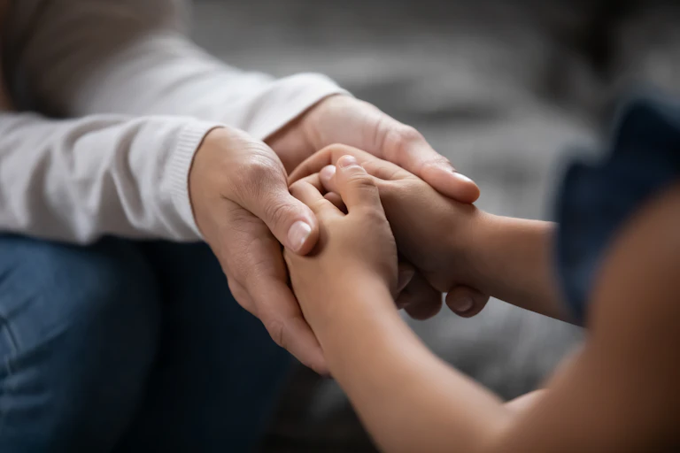 Adult hands holding a child's hands
