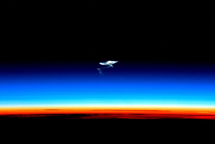 Photo showing a plume of smoke floating above Earth's atmosphere.