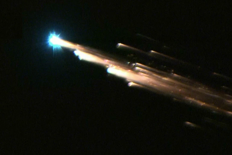 Photo showing several burning fragments of a satellite falling through the sky.