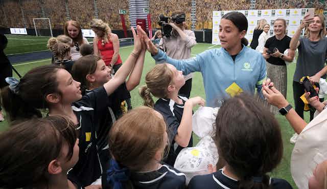 School children share high fives with Australian soccer star Sam Kerr