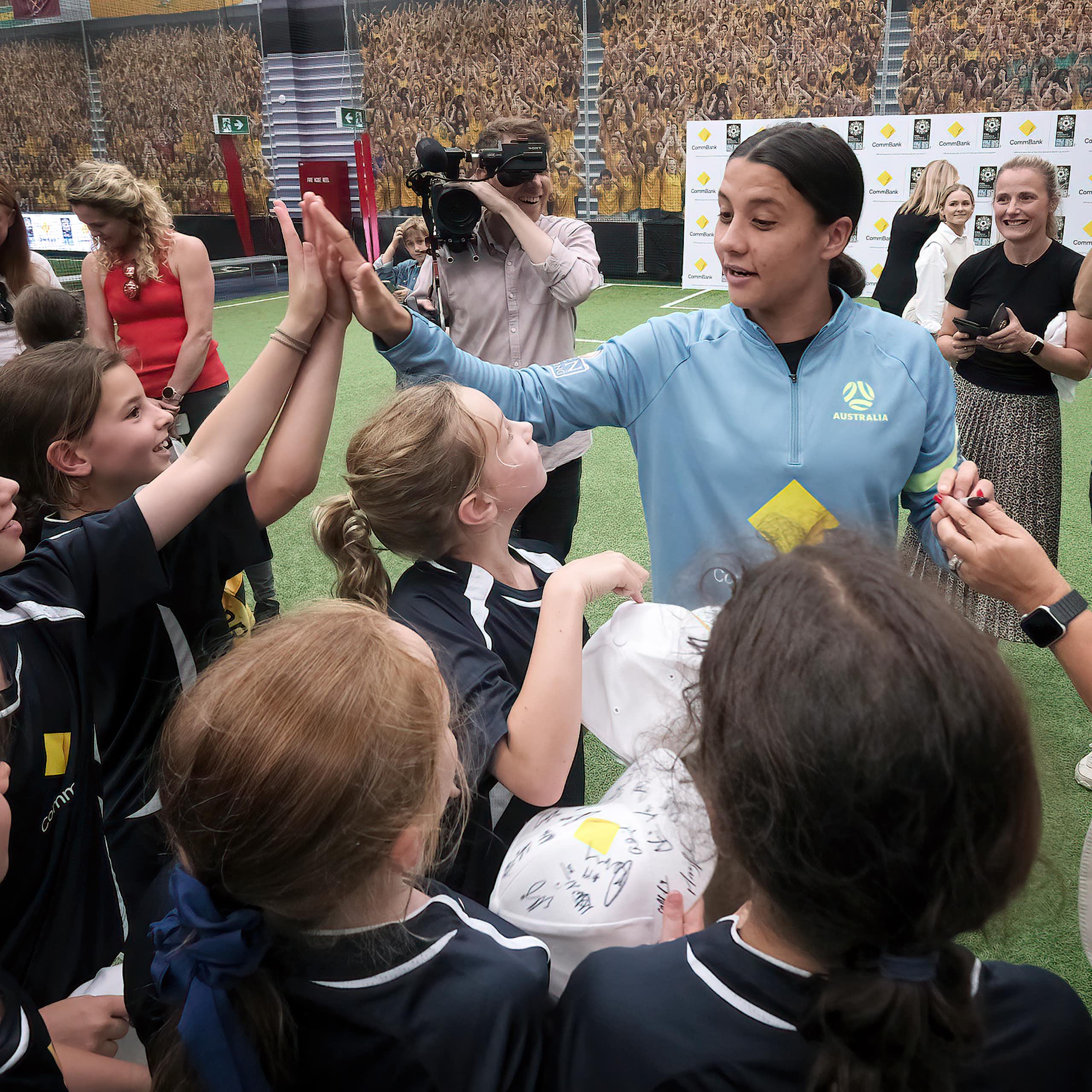 School children share high fives with Australian soccer star Sam Kerr