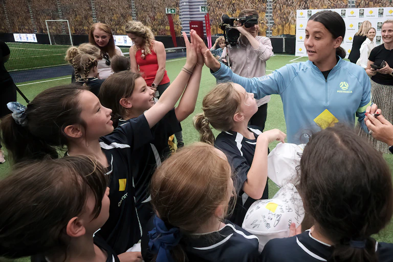 School children share high fives with Australian soccer star Sam Kerr