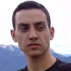 Close-up face of a young man with mountains behind