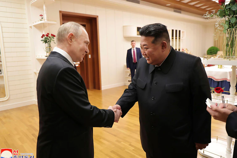 Vladimir Putin and Kim Jung Un shake hands at a June 2024 meeting.